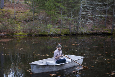 Man fishing while sitting in boat on lake - CAVF39938