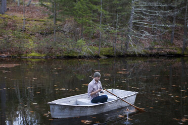 Mann beim Angeln in einem Boot auf einem See sitzend - CAVF39938