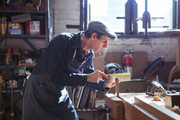 Zimmermann schneidet Holz mit Handsäge in der Werkstatt - CAVF39974