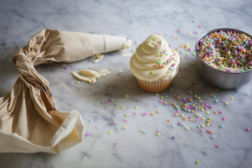 Hohe Winkel Ansicht von Zuckerguss Tasche von Cupcake und Streusel auf Küchenzeile - CAVF40008