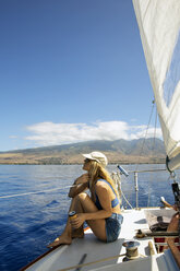 Mid adult woman sitting on yacht deck - CAVF40009