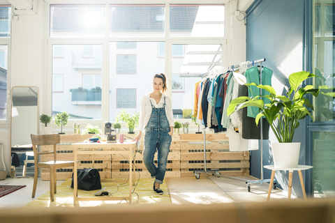 Modedesignerin in ihrem Atelier stehend, lizenzfreies Stockfoto