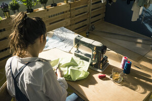 Rückenansicht einer Modedesignerin bei der Arbeit in ihrem Atelier - MOEF01010