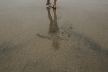 Tiefschnitt einer Frau auf nassem Sand am Strand stehend - CAVF40118