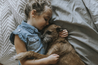 Hohe Winkel Ansicht von Mädchen schlafen mit Schnauzer auf dem Bett - CAVF40141