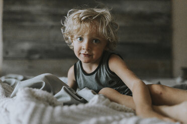 Porträt eines lächelnden Jungen, der sich auf dem Bett entspannt - CAVF40142