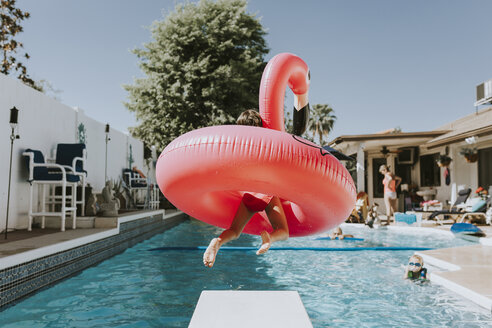 Mädchen springt ins Schwimmbad mit rosa Flamingo - CAVF40144