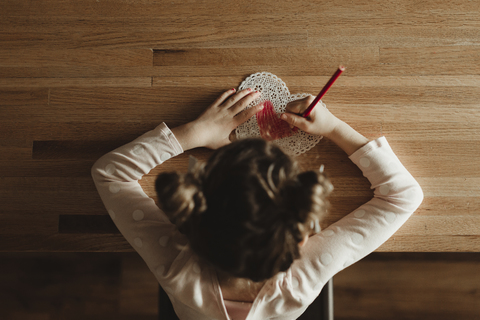 Overhead-Ansicht von Mädchen machen valentine Karte auf dem Tisch zu Hause, lizenzfreies Stockfoto