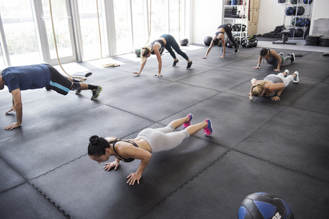 Hohe Winkel Ansicht der Athleten tun Push-ups in Crossfit Fitnessstudio, lizenzfreies Stockfoto