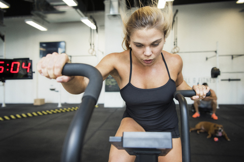 Selbstbewusster Sportler beim Training mit Seilen im Crossfit-Fitnessstudio, lizenzfreies Stockfoto