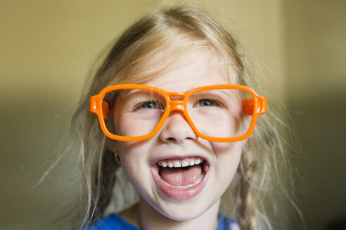 Glückliches Mädchen mit Sonnenbrillengestell zu Hause - CAVF40306