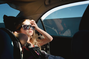 Mädchen mit Sonnenbrille sitzt im Auto - CAVF40330