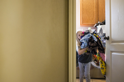 Mädchen trägt Wäsche nach Hause, lizenzfreies Stockfoto