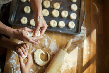 Cropped image of granddaughter and grandmother making cookies at kitchen counter - CAVF40354