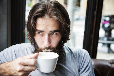 Close-up of man with beard drinking coffee while sitting at cafe - CAVF40374