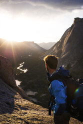 Seitenansicht eines Wanderers mit Rucksack auf einem Berg stehend gegen den Himmel - CAVF40582