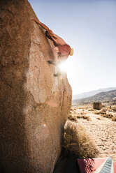 Mann ohne Hemd klettert auf Felsen gegen den klaren Himmel - CAVF40602