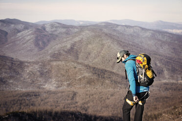 Hiker with backpack standing on top of mountain - CAVF40633