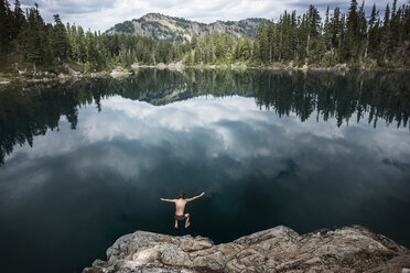 High angle view of hiker diving in lake against forest at Mt. Rainier National Park - CAVF40684