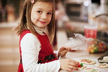 Lächelndes Mädchen bereitet Kekse am Küchentisch vor - CAVF40730