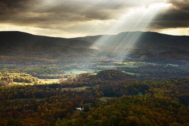 Scenic view of sunlight streaming through cloudy sky over mountain - CAVF40793