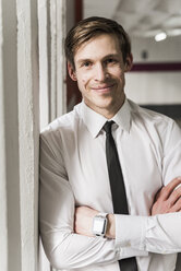 Portrait of smiling businessman wearing smartwatch - UUF13447