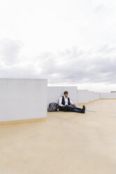 Businessman sitting at parking garage - UUF13452