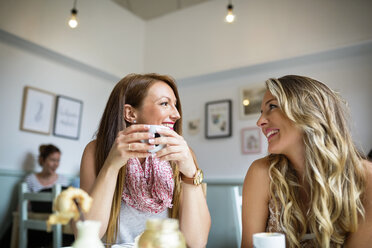 Beautiful female friends talking in coffee shop - CAVF40833