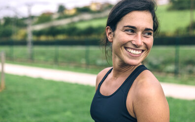 Glückliche Sportlerin, die beim Sport im Park wegschaut - CAVF40886