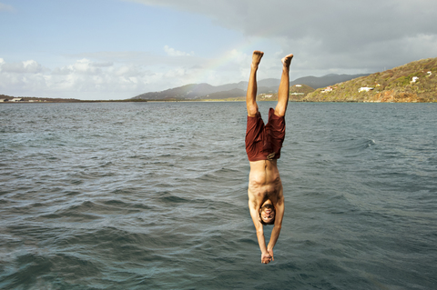 Junger Mann taucht ins Meer, lizenzfreies Stockfoto