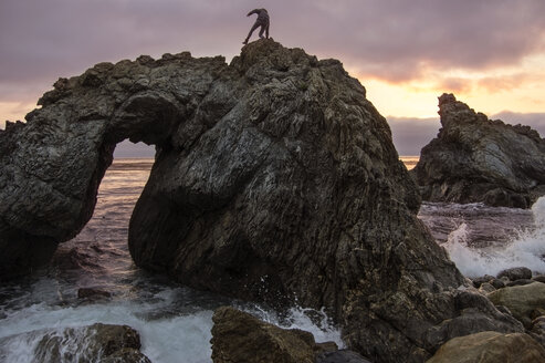 Frau steht auf einer Felsformation in Big Sur - CAVF40920