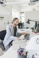 Businessman using computer in creative office - CAVF40978