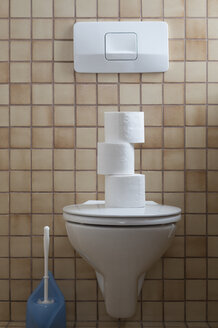 Toilette mit Stapel von Toilettenpapier - CRF02787