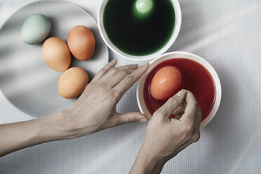 Cropped hands of woman making Easter eggs with dye at home - CAVF41284