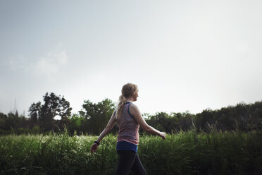 Seitenansicht einer Frau beim Joggen gegen den Himmel im Park - CAVF41290