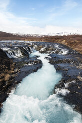 Scenic view of river flowing on rocky landscape against sky - CAVF41372