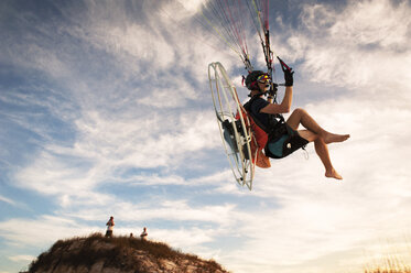 Low angle view of man paragliding against sky - CAVF41383