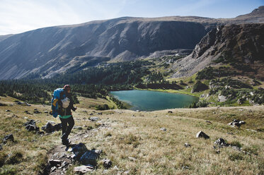 Woman hiking on mountain by lake - CAVF41401