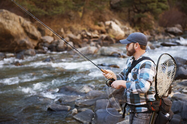 Man fishing in river at forest - CAVF41416