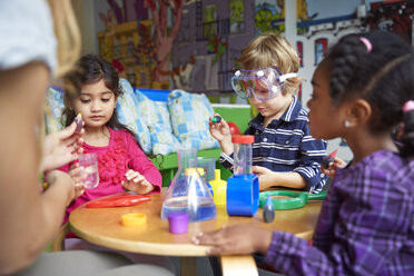 Children doing science experiment at table in preschool - CAVF41526