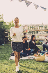 Porträt einer glücklichen Frau mit Frühstück auf einer Dachterrassenparty - MASF04695