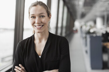 Portrait of happy businesswoman standing in office - MASF04736