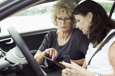 Ältere Freundinnen benutzen ein digitales Tablet im Auto - MASF04743