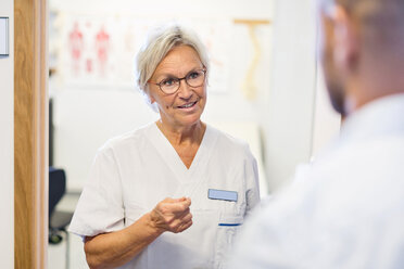 Oberarzt im Gespräch mit einem Mann in einer orthopädischen Klinik - MASF04779