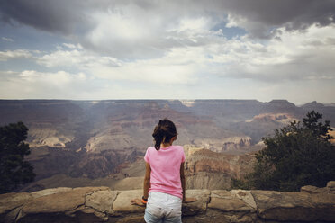 Rear view of girl looking at view while standing on mountain - CAVF41726