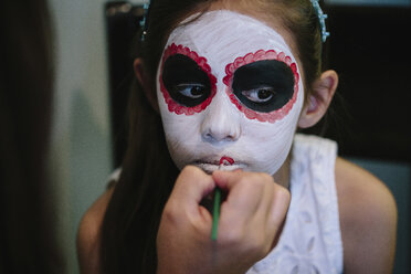 Ausgeschnittenes Bild einer Frau, die zu Hause Make-up auf das Gesicht ihrer Tochter aufträgt - CAVF41749