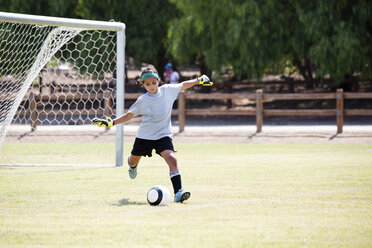 Girl playing soccer in playground - CAVF41758