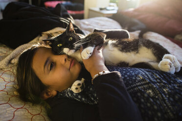 Mädchen mit Katze entspannt auf dem Bett zu Hause - CAVF41763