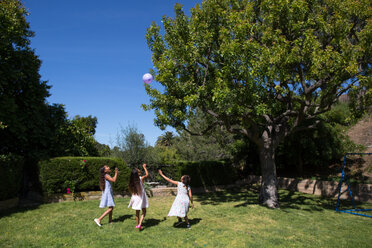 Female friends playing with balloon at yard - CAVF41832