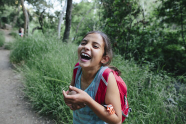 Portrait of girl laughing while standing in forest - CAVF41865